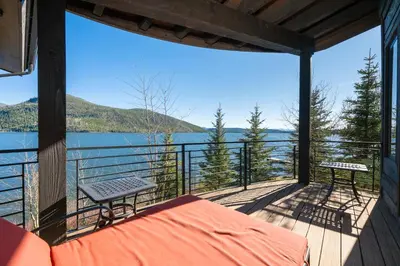 a balcony with a bed and a view of the water at LP Lakefront House - Private Dock, 7000+ Square Feet of Space, Stunning Views, Impeccable Quality in Grand Lake