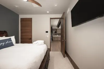 a bedroom with a bed and a flat screen tv at LP Lakefront House - Private Dock, 7000+ Square Feet of Space, Stunning Views, Impeccable Quality in Grand Lake