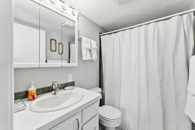 a white bathroom with a sink and a toilet at Treehouse C106 - Renovated Condo with Great Amenities, Central Summit County Location in Silverthorne