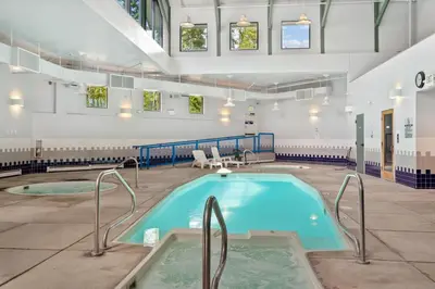 a swimming pool in a building with two jacuzzles at Treehouse C106 - Renovated Condo with Great Amenities, Central Summit County Location in Silverthorne