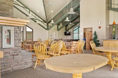 a restaurant with tables and chairs and a stone wall at Treehouse C106 - Renovated Condo with Great Amenities, Central Summit County Location in Silverthorne