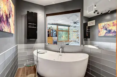 a bathroom with a white tub and a mirror at River Bank Lodge 2916 in Snake River Health Services Incorporated Heliport