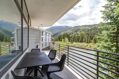 a balcony with two tables and chairs and mountains at River Bank Lodge 2916 in Snake River Health Services Incorporated Heliport
