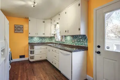 a kitchen with white cabinets and a window at Explore the Front Range! Lakewood Home with Yard in Lakewood