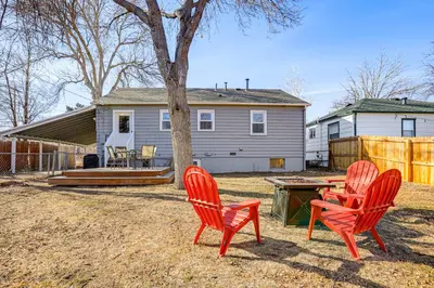 three red chairs and a table in front of a house at Explore the Front Range! Lakewood Home with Yard in Lakewood