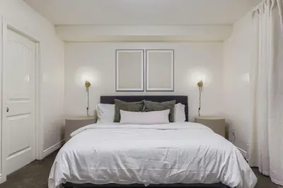 a white bedroom with a large bed with two lamps at 6BR Luxury Denver Retreat-Sleeps -14 - 7 Baths in Denver