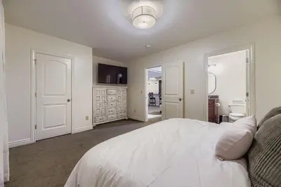 a bedroom with a white bed and a bathroom at 6BR Luxury Denver Retreat-Sleeps -14 - 7 Baths in Denver