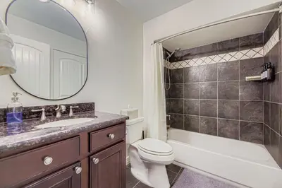 a bathroom with a sink and a toilet and a mirror at 6BR Luxury Denver Retreat-Sleeps -14 - 7 Baths in Denver
