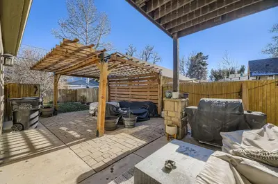 a patio with a wooden pergola and a fence at 6BR Luxury Denver Retreat-Sleeps -14 - 7 Baths in Denver