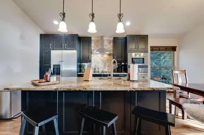 a kitchen with a large island with black cabinets at Hygge Haus - 2BD Lake View & Pet Friendly Retreat in Dillon