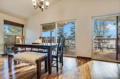 a dining room with a table and chairs and large windows at Hygge Haus - 2BD Lake View & Pet Friendly Retreat in Dillon