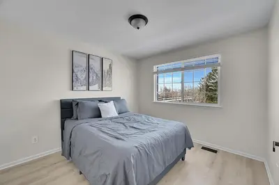 a white bedroom with a bed and a window at Your Home Away From Home ! in DEN