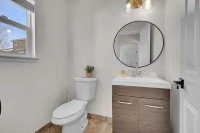 a white bathroom with a toilet and a mirror at Your Home Away From Home ! in DEN