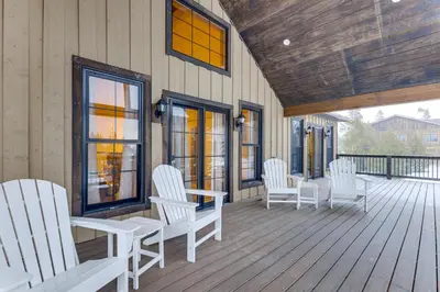 a porch with white chairs and windows on a house at Ride-InandRide-Out Grand Lake Hub Near Lakes and RMNP in Grand Lake