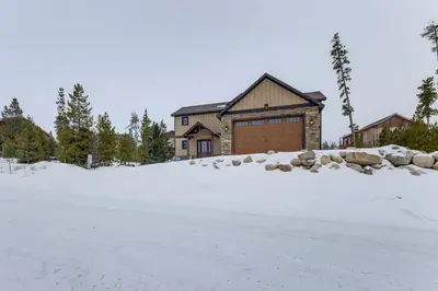 a house with a garage in the snow at Ride-InandRide-Out Grand Lake Hub Near Lakes and RMNP in Grand Lake