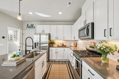 a kitchen with white cabinets and a sink at Cozy Mountain View Getaway! in Arvada