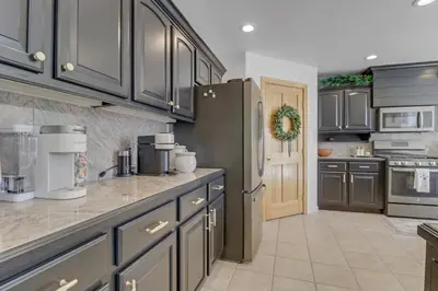 a kitchen with gray cabinets and a refrigerator at Pedal and Peak 113A townhouse in Dillon