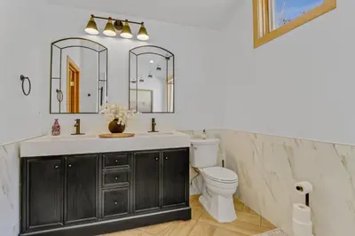 a bathroom with a sink and a toilet and mirrors at Pedal and Peak 113A townhouse in Dillon