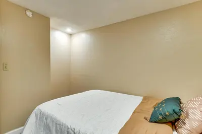 a bedroom with a bed with a white sheet and pillows at Extended Stay in Denver Area! Pet-Friendly Retreat in Aurora