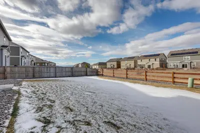 an icy driveway in a residential neighborhood with houses at Work and Play! Denver-Area Home with Fenced Backyard in Fort Lupton