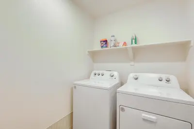a white laundry room with a washer and dryer at Work and Play! Denver-Area Home with Fenced Backyard in Fort Lupton