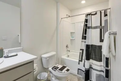 a white bathroom with a toilet and a shower at Work and Play! Denver-Area Home with Fenced Backyard in Fort Lupton
