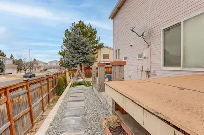 a house with a wooden fence next to a yard at Extended Stay in Denver! Cozy Apartment with Patio in Denver