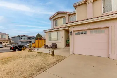 a house with a white garage and a driveway at Extended Stay in Denver! Cozy Apartment with Patio in Denver