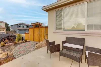 a patio with two chairs and a table and a fence at Extended Stay in Denver! Cozy Apartment with Patio in Denver