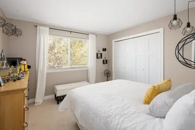 a bedroom with a large white bed and a window at Mountain View Modern Oasis - Swim Spa -Steam -More in Broomfield