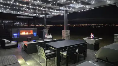 a living room with a table and a tv and a fireplace at Mountain View Modern Oasis - Swim Spa -Steam -More in Broomfield