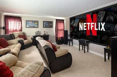 a living room with couches and a netflix sign on the wall at Mountain View Modern Oasis - Swim Spa -Steam -More in Broomfield