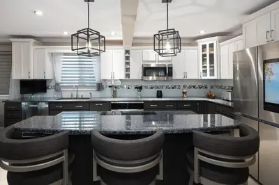 a kitchen with a large island with bar stools at Mountain View Modern Oasis - Swim Spa -Steam -More in Broomfield