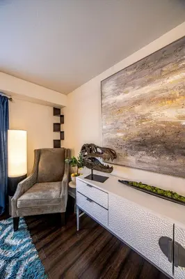 a living room with a chair and a large painting at Amazing Lake View Heated Pool Swim Spa and Hot Tub in Thornton