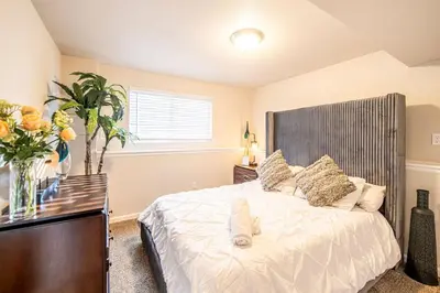 a bedroom with a large white bed and a window at Amazing Lake View Heated Pool Swim Spa and Hot Tub in Thornton