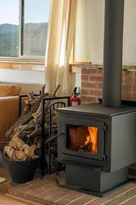 a stove in a living room with a fireplace at Skyline Lodge with Private Sauna & Hot Tub in Idaho Springs