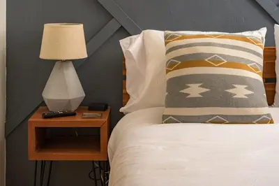 a bed with a nightstand with a lamp on it at Skyline Lodge with Private Sauna & Hot Tub in Idaho Springs