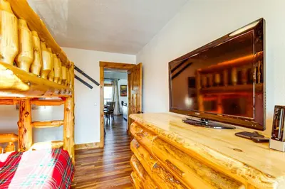 a bedroom with a large television and a bunk bed at Inviting and Cozy Fraser Condo Steps to Ski Shuttle in Fraser