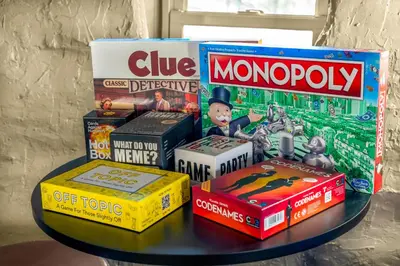 a table with a pile of games and books on it at Royal Elk Lodge Hot Tub Sauna Theatre Speakeasy in Bailey
