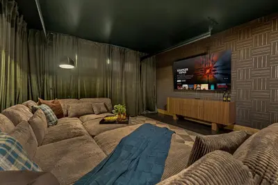 a living room with a couch and a flat screen tv at Royal Elk Lodge Hot Tub Sauna Theatre Speakeasy in Bailey