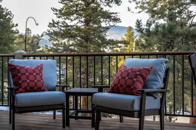 two chairs and a table on a deck at Royal Elk Lodge Hot Tub Sauna Theatre Speakeasy in Bailey
