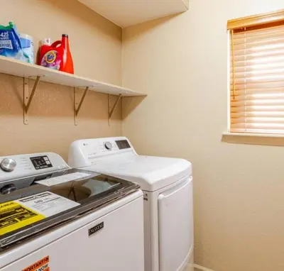 a laundry room with a washing machine and shelves at Freesan in DEN