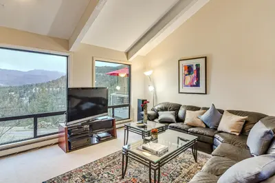 a living room with a couch and a tv at Stunning Snowcapped Mtn Views! Evergreen Home in Evergreen
