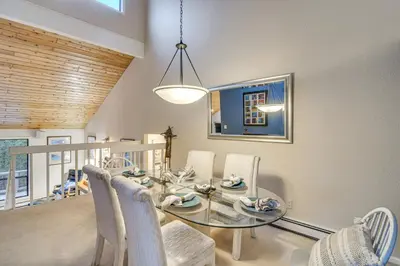 a dining room with a glass table and chairs at Stunning Snowcapped Mtn Views! Evergreen Home in Evergreen