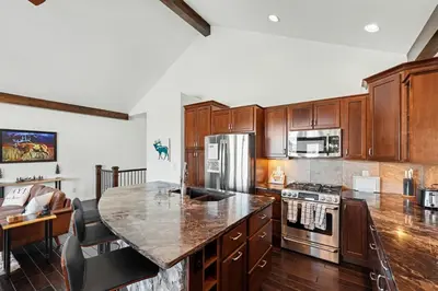 a kitchen with wooden cabinets and a granite counter top at Luxury Mountain Retreat Hot Tub Sauna Views in Estes Park