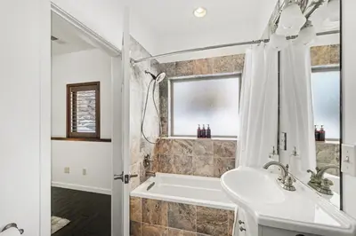 a white bathroom with a tub and a sink at Luxury Mountain Retreat Hot Tub Sauna Views in Estes Park