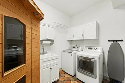 a kitchen with white cabinets and a washer and dryer at Luxury Mountain Retreat Hot Tub Sauna Views in Estes Park