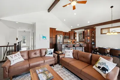 a living room with two brown couches and a kitchen at Luxury Mountain Retreat Hot Tub Sauna Views in Estes Park