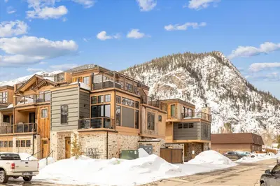 a large house in front of a mountain at Experience the charm of Frisco in this spacious townhome, Decked Out Downtown, private hot tub in Frisco