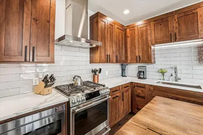 a kitchen with wooden cabinets and a stove top oven at Experience the charm of Frisco in this spacious townhome, Decked Out Downtown, private hot tub in Frisco